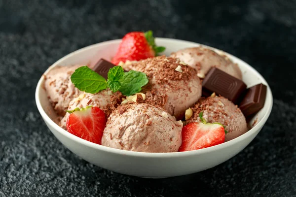 Gelato al cioccolato con barrette di cioccolato fondente, fragole e nocciole in una ciotola bianca — Foto Stock