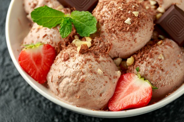 Gelato al cioccolato con barrette di cioccolato fondente, fragole e nocciole in una ciotola bianca — Foto Stock