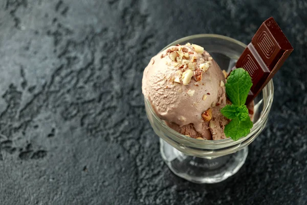 Gelato al cioccolato con barrette di cioccolato fondente e nocciole in una ciotola di vetro — Foto Stock