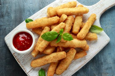 Çıtır Halloumi peyniri, beyaz tahta üzerinde acı soslu patates kızartması.