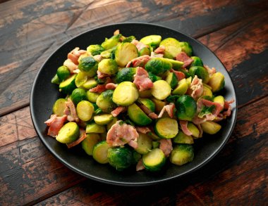 Siyah tabakta domuz pastırmalı rosto. ahşap masa