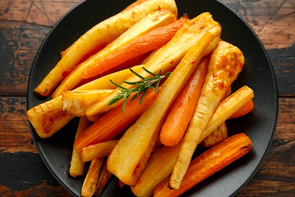 Tortas asadas y zanahorias con hierbas en mesa de madera rústica — Foto de Stock