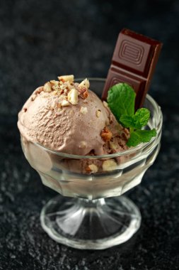 Koyu çikolatalı dondurma ve cam kasede fındık.