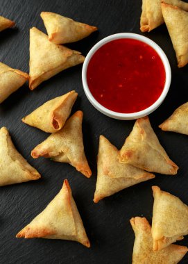 Köy taşından yapılma tahtaya tatlı acı biber soslu taze Hint Samosa