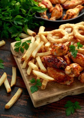 Kızarmış tavuk kanadı, soğan halkaları, patates kızartması ve sos. Yemeği götür..