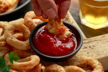 Kızarmış tavuk kanadı, soğan halkaları, patates kızartması ve sos. Yemeği götür..