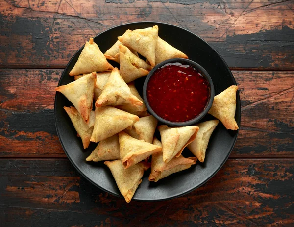 Samosa indiana fresca con salsa di peperoncino dolce intingente sul tavolo di legno — Foto Stock