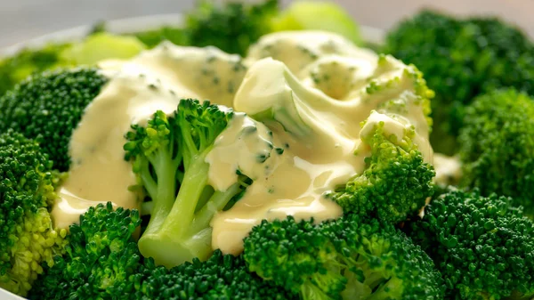 Brócoli con salsa de queso en tazón blanco sobre mesa de madera — Foto de Stock