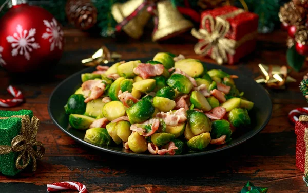 Christmas Brussel Sprouts and Bacon with decoration, gifts, green tree branch on wooden rustic table — Stock Photo, Image