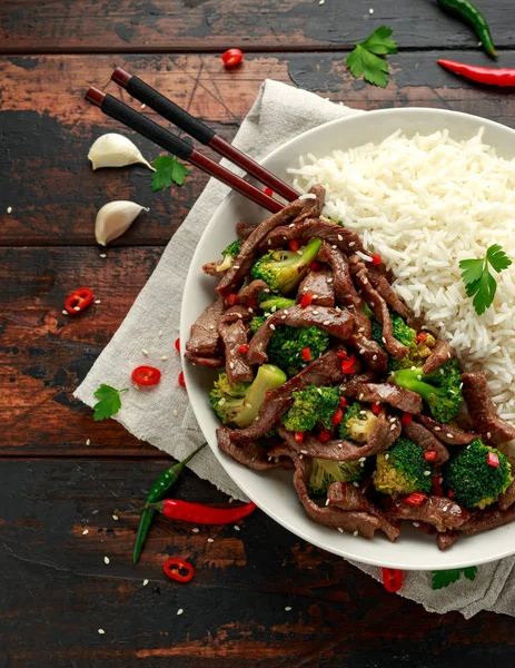 Hausgemachtes Rindfleisch und Brokkoli mit Reis und Kräutern auf Holztisch — Stockfoto