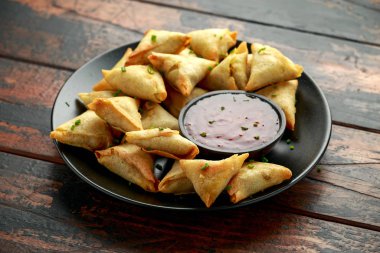 Ahşap masaya tatlı biber soslu taze Hint Samosa 'sı.