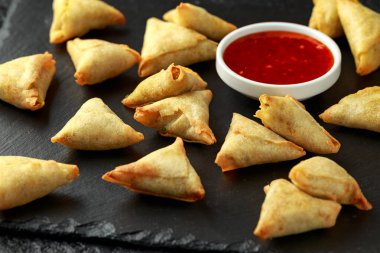 Köy taşından yapılma tahtaya tatlı acı biber soslu taze Hint Samosa