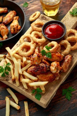 Kızarmış tavuk kanadı, soğan halkaları, patates kızartması ve sos. Yemeği götür..