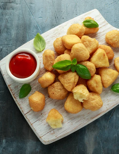 Fried mozzarella, cheddar cheese bites, balls with ketchup on white wooden board — ストック写真