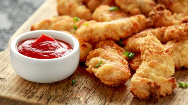 Tahtada ketçap ve tereyağlı tavuk nugget.