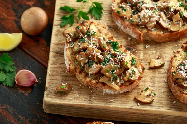 Tostadas de setas a la parrilla con perejil, limón y queso parmesano sobre tabla de madera. comida vegana saludable —  Fotos de Stock