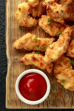 Tahtada ketçap ve tereyağlı tavuk nugget.