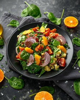 Kırmızı soğanlı sebze Millet salatası, vişneli domates, ıspanak, mandalina ve mandalina sosu. sağlıklı yiyecekler