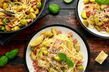 Ev yapımı Brüksel lahanası, pastırma, parmesan peynirli pancetta makarna. Tahta masada.