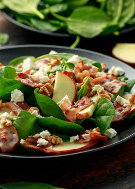 Pastırma, ıspanaklı elma salatası, ceviz ve peynir. Tahta masada. sağlıklı yiyecekler.