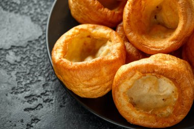 Geleneksel İngiliz Yorkshire pudingi siyah tabak ve arkaplan üzerine