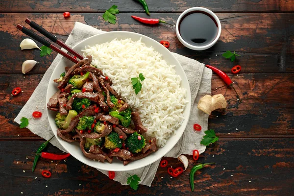 Hausgemachtes Rindfleisch und Brokkoli mit Reis und Kräutern auf Holztisch — Stockfoto