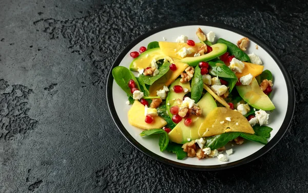 Хурма, салат из авокадо со шпинатом, сыром фета, грецкими орехами и семенами граната. Здоровое питание . — стоковое фото