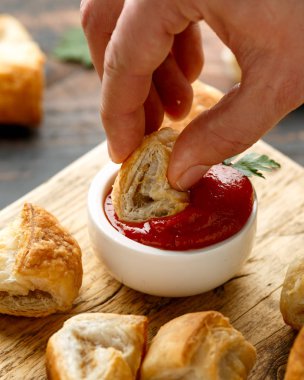 Ahşap tahtada hardal ve ketçap soslu domuz sucuğu rulosu.