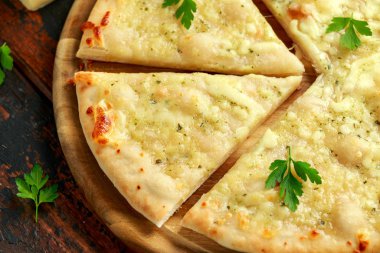 Tahtada otlarla sarımsaklı peynirli pizza..