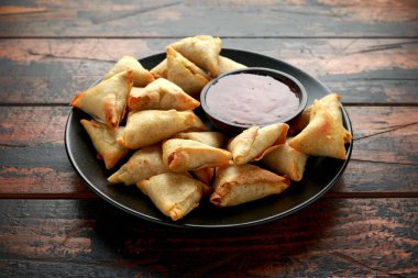 Ahşap masaya tatlı biber soslu taze Hint Samosa 'sı.