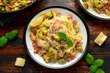 Ev yapımı Brüksel lahanası, pastırma, parmesan peynirli pancetta makarna. Tahta masada.