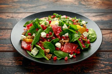 Ispanaklı, cevizli, nar tohumlu ve peynirli portakal greyfurt salatası. sağlıklı yiyecekler