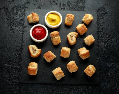 Köy taşında hardallı domuz sosisi ve ketçap.