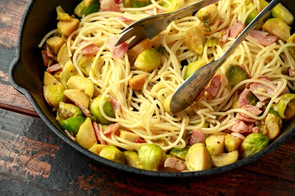 Ev yapımı Brüksel lahanası, pastırma, parmesan peynirli pancetta makarna. Tahta masada.