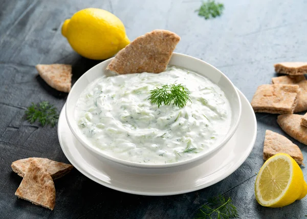 Salsa de salsa Tzatziki con yogur griego, ajo, eneldo y pepino en un tazón blanco — Foto de Stock