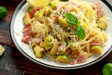 Ev yapımı Brüksel lahanası, pastırma, parmesan peynirli pancetta makarna. Tahta masada.