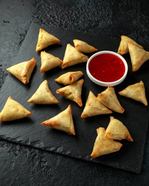 Köy taşından yapılma tahtaya tatlı acı biber soslu taze Hint Samosa