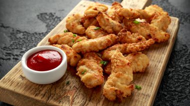 Tahtada ketçap ve tereyağlı tavuk nugget.