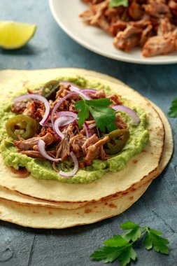 Mexican Corn tortilla with shredded Pork, avocado, red onion and jalapeno clipart