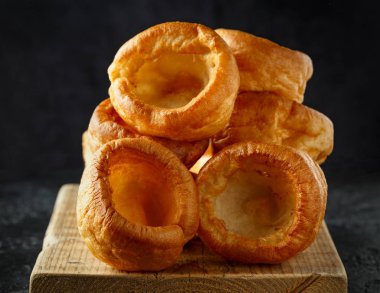 Geleneksel İngiliz Yorkshire pudingi siyah tabak ve arkaplan üzerine