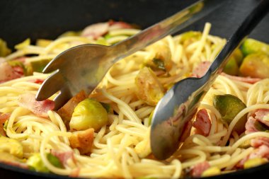 Ev yapımı Brüksel lahanası, pastırma, parmesan peynirli pancetta makarna. Tahta masada.