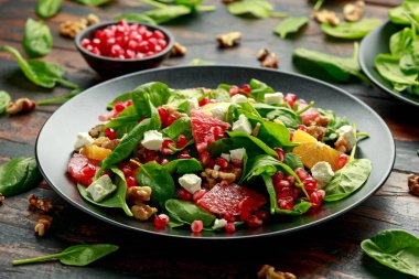Ispanaklı, cevizli, nar tohumlu ve peynirli portakal greyfurt salatası. sağlıklı yiyecekler