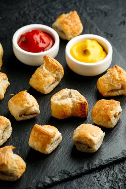 Köy taşında hardallı domuz sosisi ve ketçap.