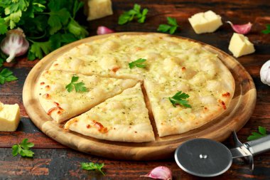 Tahtada otlarla sarımsaklı peynirli pizza..