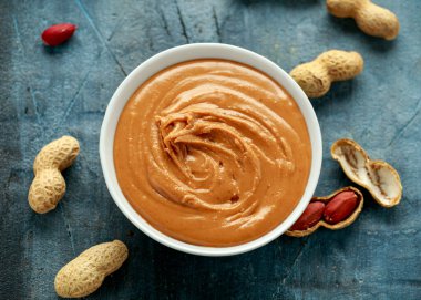 Smooth Peanut Butter in white bowl with nuts