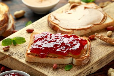 Peanut Butter and strawberry Jelly Sandwich on wooden board. morning breakfast