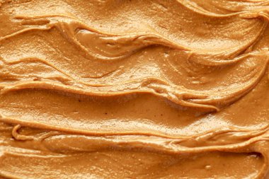 Fresh smooth Peanut Butter closeup background, texture