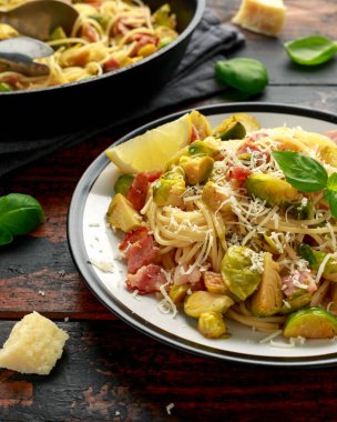 Ev yapımı Brüksel lahanası, pastırma, parmesan peynirli pancetta makarna. Tahta masada.