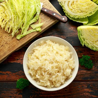 Fresh pickled cabbage in white bowl on wooden table. healthy food