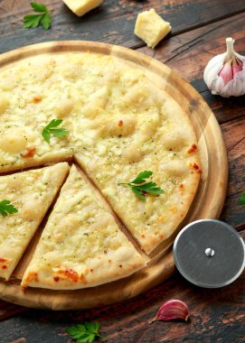 Tahtada otlarla sarımsaklı peynirli pizza..